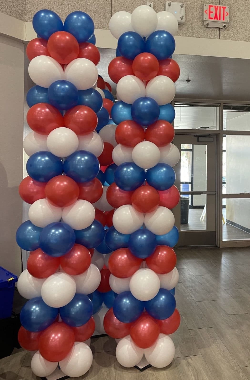 Red, white and blue balloon columns inside a venue lobby